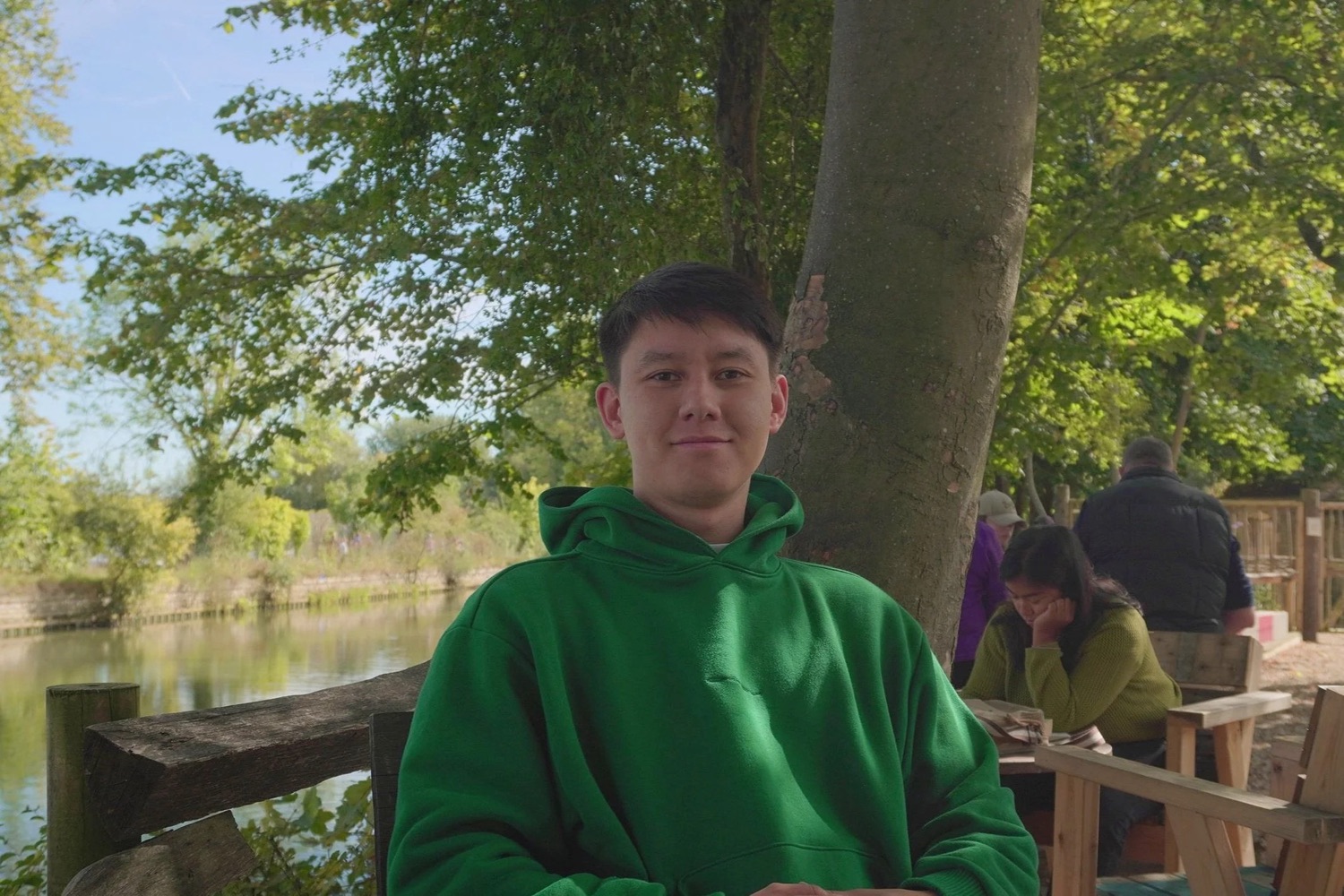 John, sitting by a river under a tree