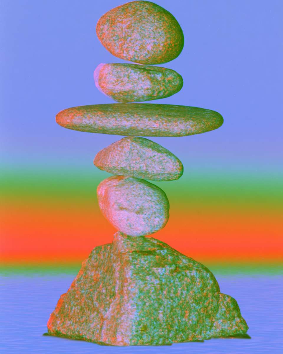 A balanced cairn of stones against bands of colour